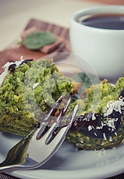 Vintage photo, Fresh muffins with spinach, desiccated coconut, chocolate glaze and cup of coffee, delicious healthy dessert