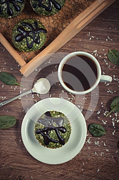 Vintage photo, Fresh muffins with spinach, desiccated coconut, chocolate glaze and cup of coffee, delicious healthy dessert