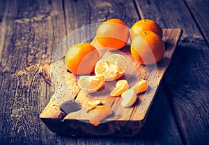 Vintage photo of fresh tangerines on wooden cutting board