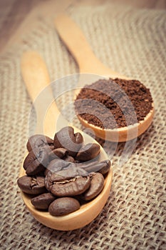 Vintage photo, Grains and ground coffee with wooden spoon on jute canvas