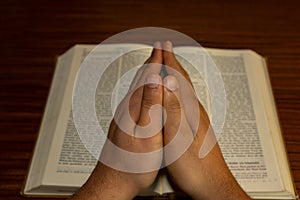 Vintage photo of hand with Bible praying , Hands folded in prayer on a Holy Bible , Jesus Christ