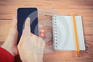 Vintage photo, Hand of woman using mobile phone, notepad for writing notes