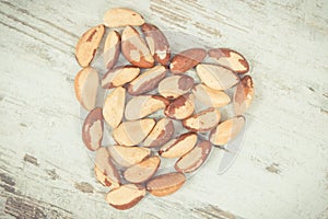 Vintage photo, Heap of brazil nuts in shape of heart, healthy food containing natural minerals