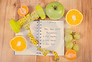 Vintage photo, New years resolutions written in notebook and dumbbells with centimeter