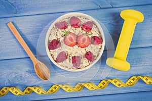 Vintage photo, Oat flakes with fruits, dumbbells and centimeter, slimming and healthy lifestyle concept