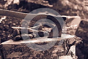 Vintage photo of an old axe and work gloves