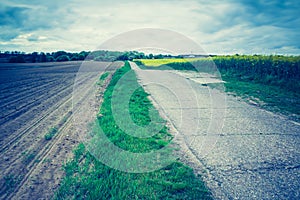 Vintage photo of rural asphalt road near fields