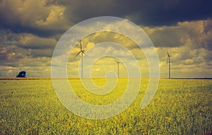 Vintage photo of windmills standing on corn field