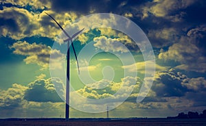 Vintage photo of windmills standing on corn field