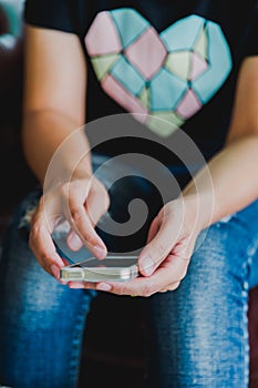 Vintage photo of woman using mobile smart phone in coffee shop.