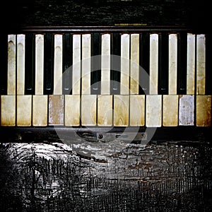 A Vintage Piano Keyboard With Charred Wood Accent.