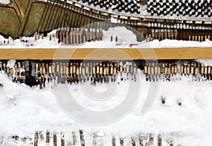 Vintage Piano musical instrument under the snow.