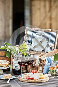 Vintage picnic hamper with wine, cheese and tart