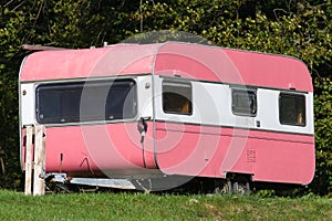 Vintage pink caravan in campsite.