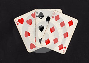 Vintage playing cards showing a hand of three eights.