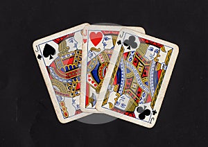 Vintage playing cards showing a hand of three jacks.
