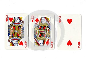 Vintage playing cards showing a pair of queens and a two.