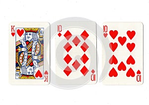 Vintage playing cards showing a pair of tens and a king.