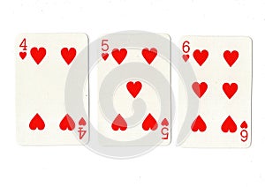 Vintage playing cards showing a run of hearts.