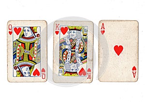 Vintage playing cards showing a run of queen, king and ace of hearts.