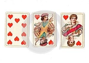 Vintage playing cards showing a run of a ten, jack and queen of hearts.