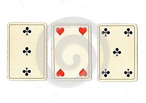 Vintage playing cards showing a three card in different suits.