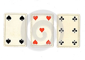 Vintage playing cards showing a three card in different suits.