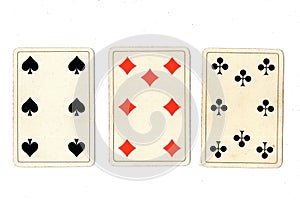 Vintage playing cards showing a three card in different suits.