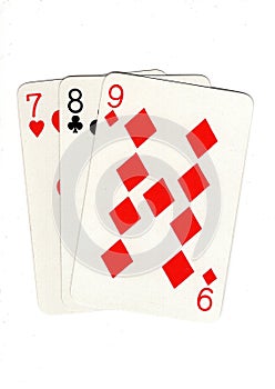 Vintage playing cards showing a three card run in different suits.