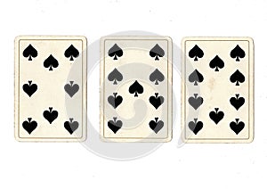 Vintage playing cards showing a three card run of spades.