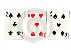 Vintage playing cards showing three fives.