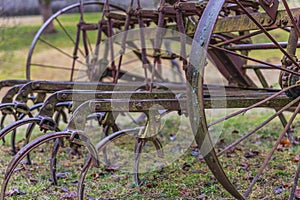 Vintage plowing machine in the field. Old rusted farm machinery. Old rusty plow and planter