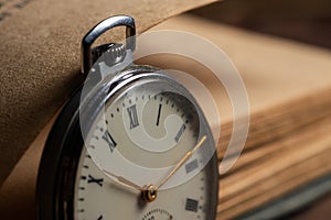 Vintage pocket watch on the background of old books