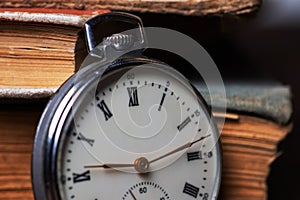 Vintage pocket watch on the background of old books