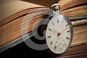 Vintage pocket watch on the background of old books