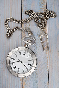 Vintage pocket watch with chain on table