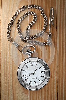 Vintage pocket watch with chain on table