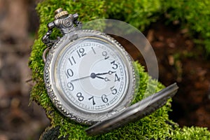 Vintage pocket watch lying on the ground, close-up, selective focus