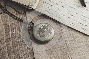 Vintage pocket watch with pen and paper
