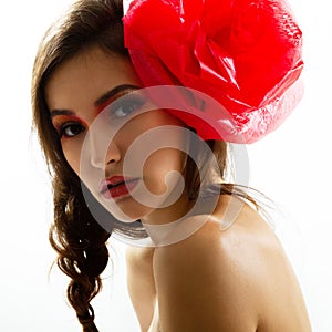 Vintage portrait of fashion glamour girl with red flower in her hair, studio shot.