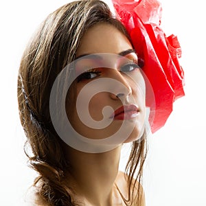 Vintage portrait of fashion glamour girl with red flower in her hair, studio shot