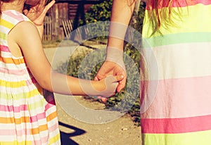 Vintage portrait of little girls holding hand in hand in summer day outdoors