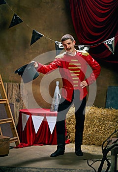 Vintage portrait of male retro circus entertainer expresses rejoice and announces start of show over dark retro circus