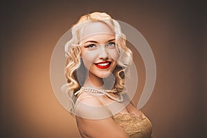 Vintage portrait. Young lady with a gold dress. Pearl beads.