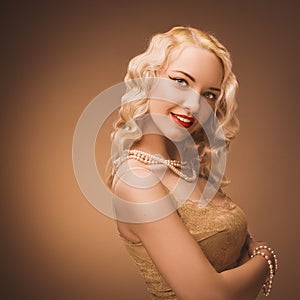 Vintage portrait. Young lady with a gold dress. Pearl beads.