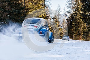 Vintage racing car drifting on classic rally snow covert road