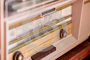 Vintage radio features a horizontal tuning scale with various frequency numbers. photo