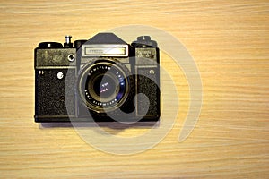 Vintage ragefinder camera on golden wooden background