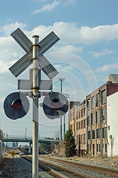 Vintage railroad crossing signal behind old warehouses in urban Atlanta Georgia