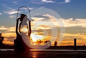 Vintage Railroad Lantern Lights Up sunset on water